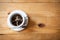 Cup of black iced coffee on wooden table. Ice coffee overhead view with copy space.