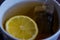 A cup of black strong tea with lemon and tea bag