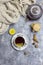 Cup with black tea and lemon and saucer, teapot, lemon, hazelnut, sticks of cinnamon and knitted scarf near, an gray background