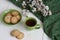 A cup of black tea on a napkin, homemade cookies, a branch of apricot bloom on the white background