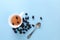 Cup of brewed Wild rose tea and heap of dried seeds, on blue background