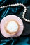 Cup of cappuccino for breakfast with satin and pearls jewellery background, organic coffee with lactose free milk in parisian cafe
