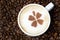 cup of cappuccino with cinnamon pattern on a background of coffee beans, horizontal