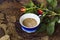 Cup of cappuccino coffee buds of roses on a dry leaf jpg