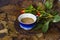 Cup of cappuccino coffee buds of roses on a dry leaf jpg