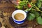 Cup of cappuccino coffee buds of roses on a dry leaf jpg