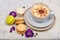 Cup of cappuccino coffee and colorful French dessert macarons