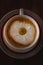 Cup of cappuccino coffee and croissant / brioche on a wooden table with freshly gathered daisy flowers. Italian breakfast.