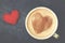 Cup of cappuccino coffee with foam in the form of heart on blue