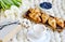 Cup with cappuccino and croissants, berries, white pastel giant knit blanket