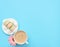The cup of cappuccino and delicious macarons with white merengues on white plate  on blue background with pink flower. Happy day,