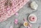 Cup with cappuccino, doughnut, pink pastel giant blanket, flowers