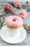 Cup with cappuccino, doughnut, pink pastel giant blanket, flowers