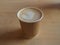 Cup of cappuccino in the paper takeaway cup on the wooden table