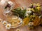 A cup of chamomile tea in a glass cup, bowl of marshmallows and a bouquet of field summer flowers on a wooden surface