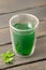 Cup of chlorophyll water on wooden table