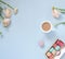 Cup of cocoa, macaroons cookies colorful in pastel colors and delicate pink ranunculus flowers on a pale blue background