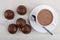 Cup of cocoa with milk, spoon on saucer, chocolate desserts with