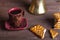 Cup of cofee, tirk and cookies on old wooden table opposite sack