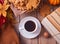 Cup of coffee, autumn leaves, pumpkin, cookies, books on the wooden table. Autumn harvest. Autumn concept. Top view