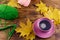 Cup of coffee, ball of yarn, knitting, knitted scarf and yellow maple leaves on wooden table. Autumn still life