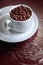 Cup with coffee beans on a brown background