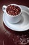 Cup with coffee beans on a brown background