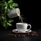 Cup of coffee on black background with coffee beans and green leaves