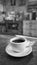 Cup of coffee in black and white with blurred cafe ambiance as background