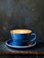 Cup of coffee in a blue cup with latte art in a beautiful aesthetic cafe on a black wooden table, morning lighting and cozy vibes