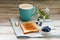 Cup with coffee with blueberries, flowers and toast