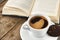 Cup of coffee with book on a wooden table.Reading a book with a cup of espresso coffee on an old vintage wooden table. Cup of coff