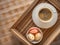 Cup of coffee and bowl of capcakes in wooden box with free space for text or label