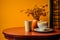 a cup of coffee and a bowl of chips sit on a table in front of an orange wall