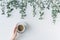 Cup of coffee in branches with green leaves on a white table. Cofee art. Flat lay, top view.