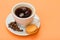 Cup of coffee with coffee beans and delicious macarons cake on peach background