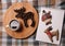 Cup of coffee, coffee beans in the shape of elk on wooden board, notebook with deer and snowman. On a plaid background