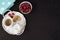 Cup of coffee, cookies a jug of milk on a straw tray. A bowl with raspberries. Black background. Top view