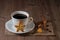 A cup of coffee and cookies like star and heart with cinnamon, coffee beans on wooden table
