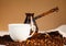 Cup of coffee, copper turk and coffee beans on the wooden surface. Close-up