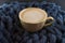 A Cup of coffee in a cozy style on a blue knitted blanket background