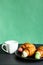 Cup of coffee and croissants on black plate on colored background with copy space