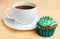Cup of coffee and cupcake with cream and decorative beads