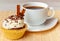 Cup of coffee and cupcake with cream and decorative chocolate sprinkles, cinnamon and anise