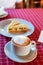 A cup of coffee and a delicious piece of a pie. Cappuccino closeup on the table.