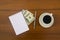 Cup of coffee, dollars, notepad and pen on wooden desk