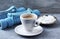 Cup of coffee, dumbbells and Beta-alanine capsules on blue wooden background.