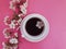 Cup of coffee espresso blooming breakfast cherry concept on a colored blossom