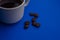 Cup of Coffee espresso with coffee beans on blue background. Flat lay, creative design