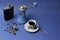 Cup of coffee, flask with cognac and manual coffee grinder on a blue background